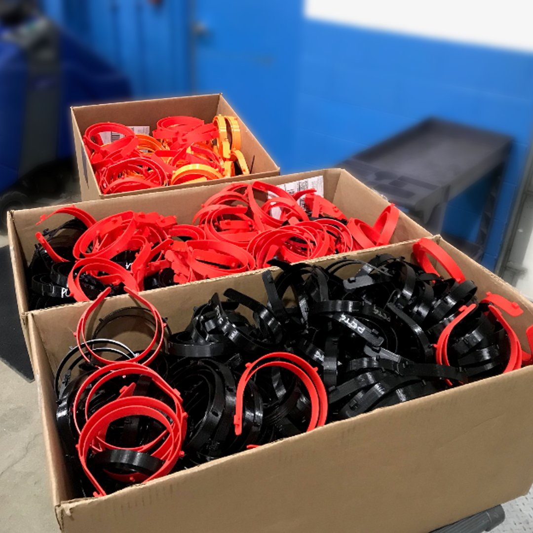 Cardboard boxes filled with headbands, the upper portion of a face shield used for personal protective equipment